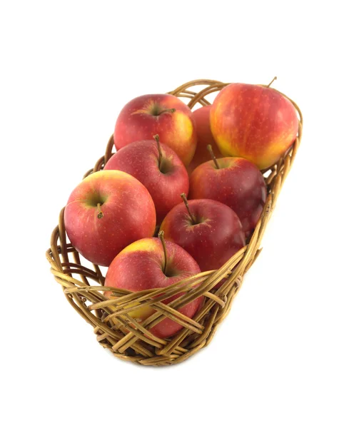 Reife rote Äpfel in langen braunen Weidenkorb isoliert — Stockfoto