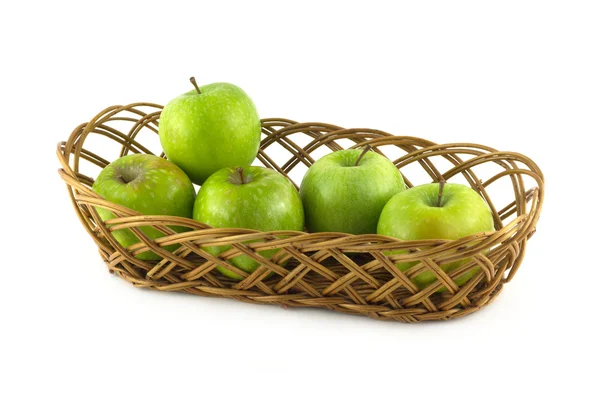 Pommes vertes mûres dans un panier long en osier brun isolé — Photo