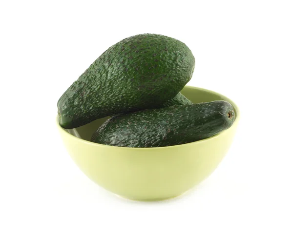 Авокадо лежит в зеленой чаше изолированный крупным планом — стоковое фото