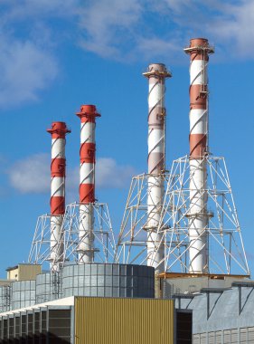 gökyüzü ve bulutlar dikey görünüm sanayi boruları yüksek binalarla güç istasyonu