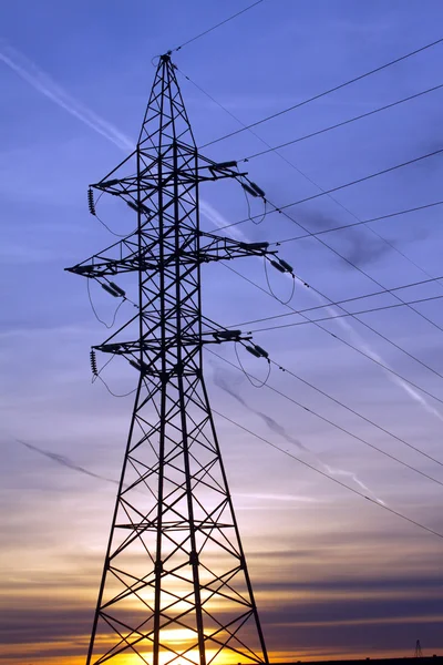 美しい日没の垂直方向のビューで電源供給ライン金属タワー — ストック写真