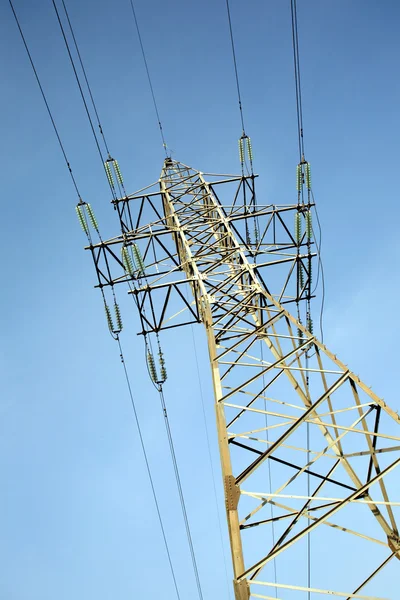 Hoog-voltage power lijn metalen prop over duidelijke wolkenloze blauwe hemel Rechtenvrije Stockafbeeldingen