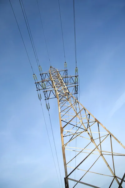 Högspännings-power line metall prop över klart molnfri blå himmel — Stockfoto