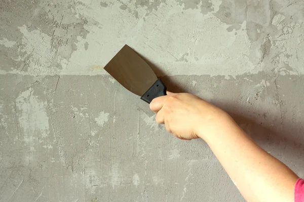 Vrouw hand met een spatel pleisters betonnen wand — Stockfoto