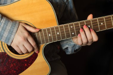 Kız bir akustik gitar closeup oynamak