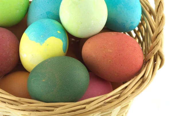 Color Easter eggs in brown basket isolated — Stock Photo, Image