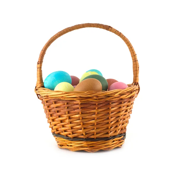 Color Easter eggs in brown basket isolated Stock Picture