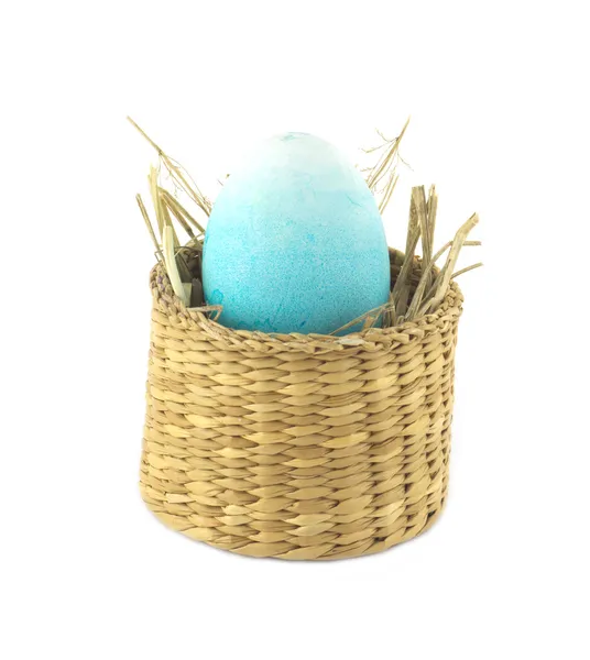 Color Easter egg in in small brown basket isolated — Stock Photo, Image
