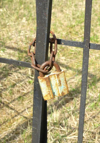 Velho cadeado enferrujado em cerca de metal fechar — Fotografia de Stock