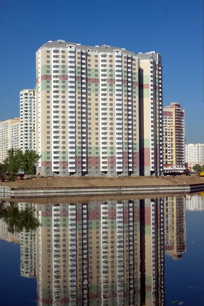 Veel blokkeren van flats over rivier en duidelijke blauwe hemel — Stockfoto