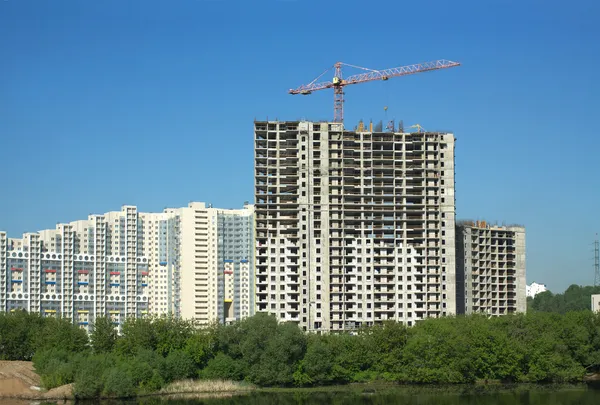 Guindaste de torre de elevação na construção de novos edifícios de apartamentos — Fotografia de Stock
