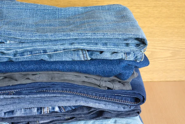 Calça jeans colorida na prateleira do armário, vista frontal close-up — Fotografia de Stock