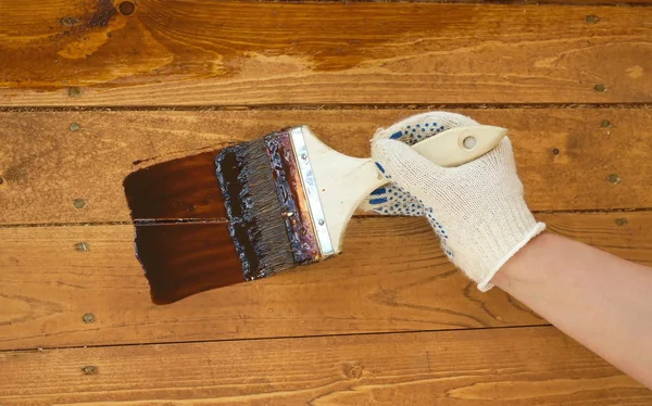 Female hand in  paints the wooden wall. Closeup photo — Stock Photo, Image