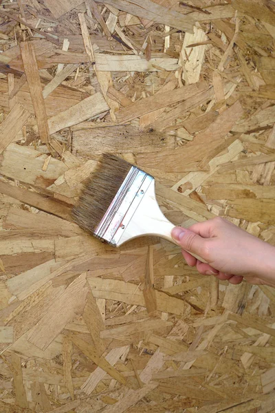 La mano de la mujer pinta la pared de madera. Foto de primer plano — Foto de Stock