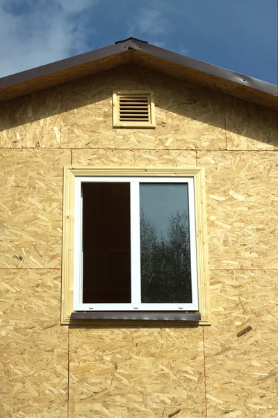 Wall from wooden panels with white plastic window and brown roof closeup — Stock Image Wall from wooden panels with white plastic window and brown roof closeup Royalty Free Stock Photos