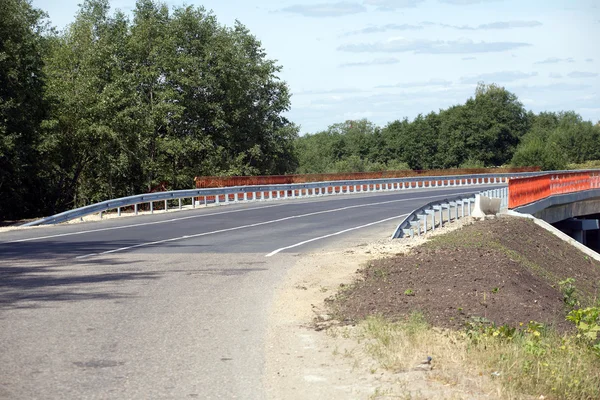 Nuevo puente en carretera suburbana con valla naranja — Foto de Stock