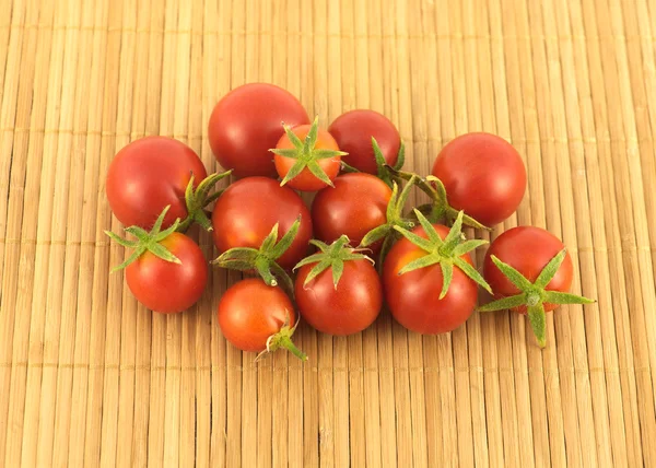 Många mogna tomater på sandiga brunt halm matta — Stockfoto