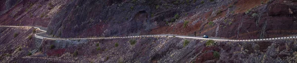 广阔的风景和一辆汽车在一条蜿蜒的山路上 乘坐汽车在西班牙加那利群岛旅行 弧形山路全景 — 图库照片