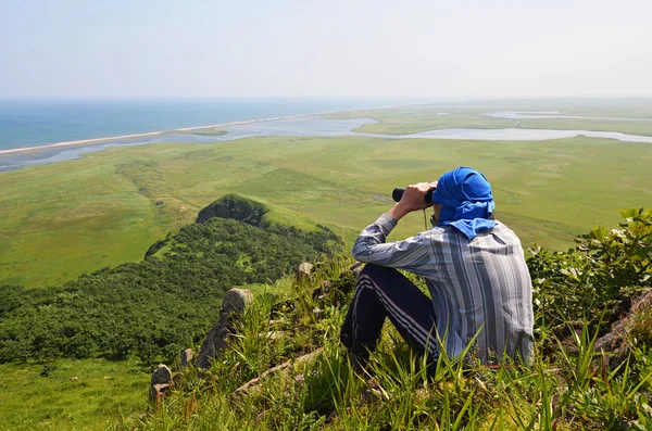 Man looking in binoculars, the border of Russia with North Korea — Stockfoto