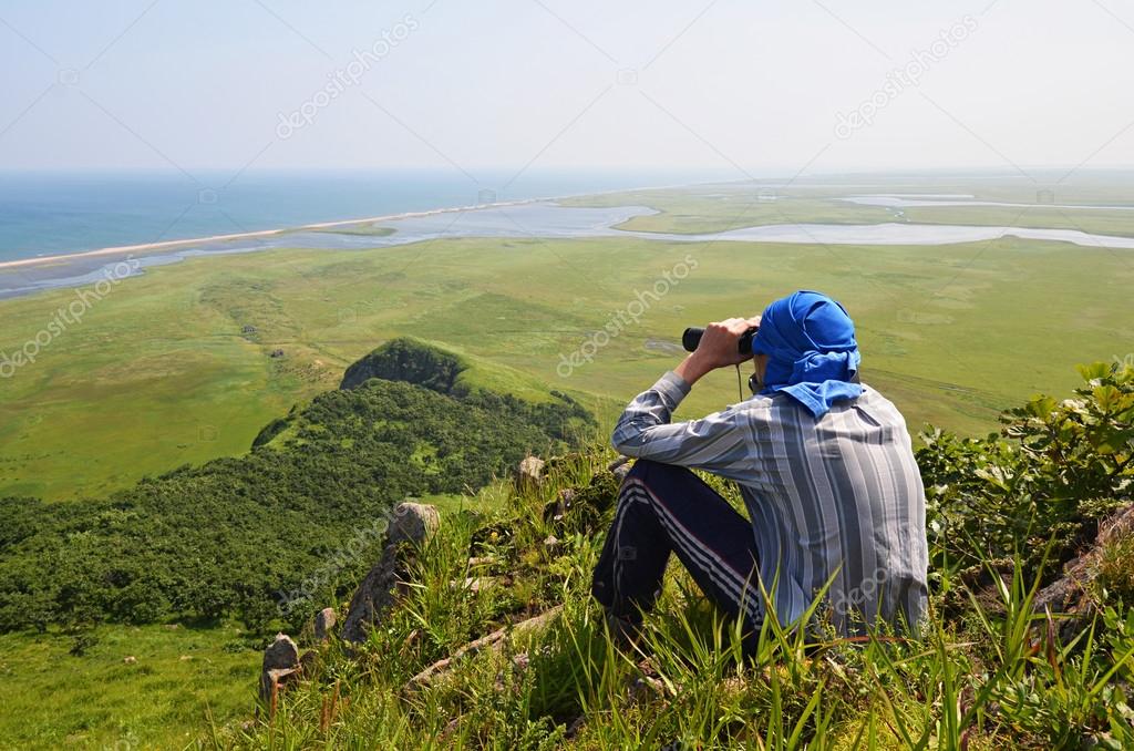 Man looking in binoculars, the border of Russia with North Korea