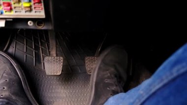Kirli eski bir arabada pedal çeviren bir erkek..