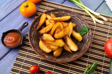 Masadaki tabakta farklı sebzelerle birlikte büyük parçalar halinde kızarmış patates..