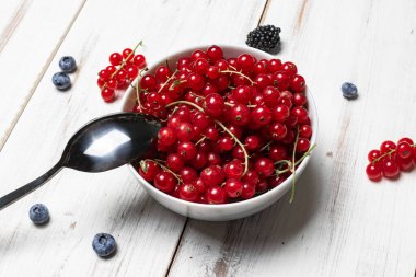 Beyaz ahşap arka planda kırmızı frenk üzümü..