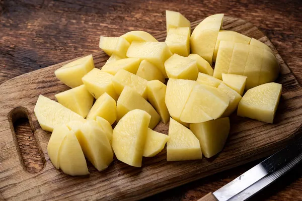 Rauwe Aardappelen Gesneden Een Houten Ondergrond Bereiding Voor Het Koken — Stockfoto