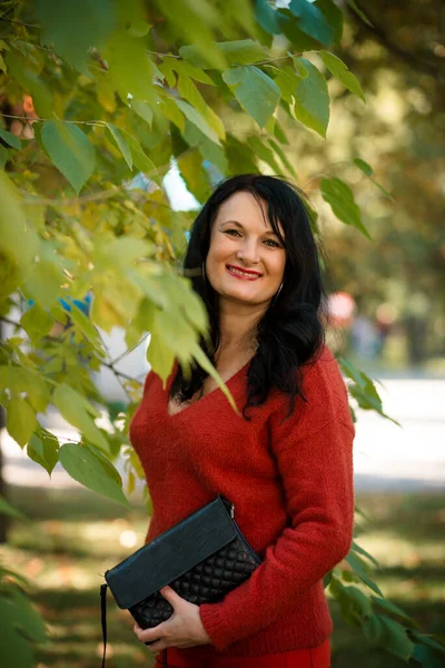 Žena Tmavými Vlasy Usmívá Parku Zeleného Stromu Červeném Svetru — Stock fotografie