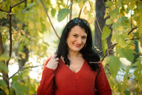 Žena Tmavými Vlasy Usmívá Parku Zeleného Stromu Červeném Svetru — Stock fotografie