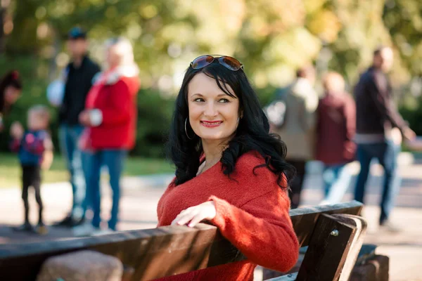 Lavičce Parku Sedí Mladá Žena Sobě Červenou Bundu Černé Vlasy — Stock fotografie