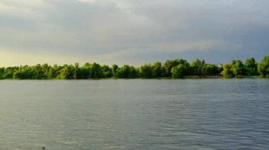 Kıyısında yeşil ağaçlar olan şehir nehri manzarası. Turizm, su seyahati kavramı.