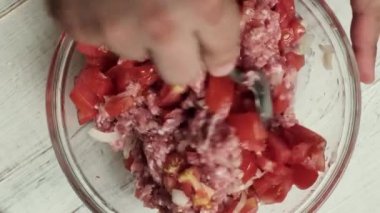 Çiğ et, soğan ve domates, yemek yapmak için yoğurulur..