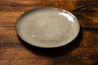 Koyu ahşap zemin üzerinde boş kil plaka