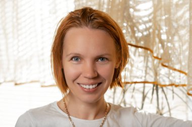 Kırklı yaşlarındaki çekici bir kadın kameraya gülümsüyor..