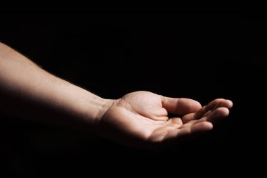 Erkek eli, avuç içi siyah arka planda. Verme, sorma konsepti.