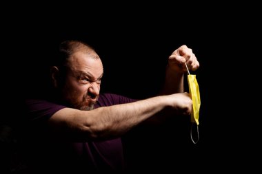 Bir adam tıbbi maske takıyor. Karantina protesto kavramı.