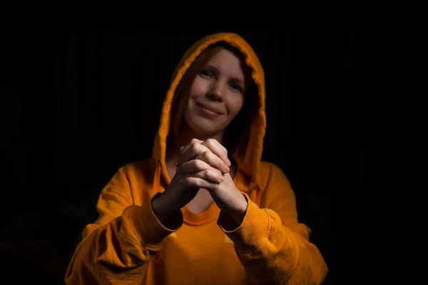 Женщина Капюшоне Держит Руки Скрещенными Пальцами Черном Фоне Вид Спереди — стоковое фото