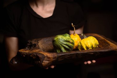 Farklı türde bir balkabağı, balkabağı çorbası. Koyu bir arka planda, ahşap bir tepside..