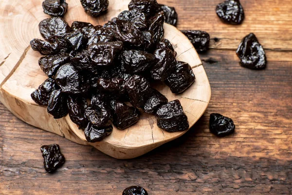 Dried prunes on a wooden background. Dry fruits.