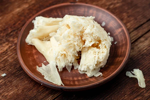 Ahşap Bir Zeminde Kil Tabakta Dilimlenmiş Sert Peynir Cipsi — Stok fotoğraf