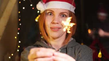 Bengal yangını, yılbaşı şapkalı bir kadının ellerinde sönüp gidiyor..