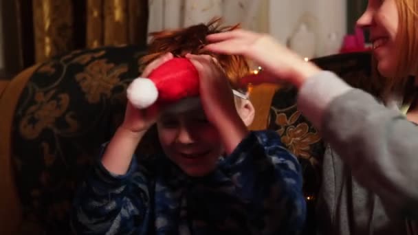 Bir Kadın Oğlu Yeni Yıl Şapkasıyla Kanepede Oturuyor Keyif Alıyorlar — Stok video