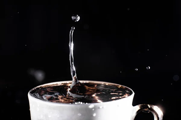 Uma Gota Água Cai Uma Xícara Sobre Fundo Preto Salpicos — Fotografia de Stock