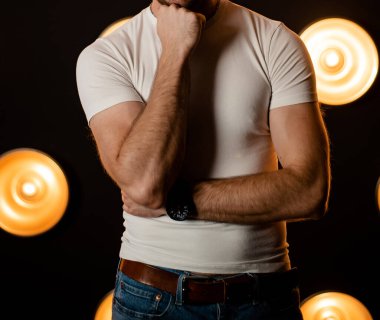 Kotlu, beyaz tişörtlü, tanınmayan şık bir adam..