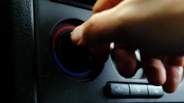 Eski bir arabanın enstrüman panelinin sıcaklık topuzunu döndürüyorum..