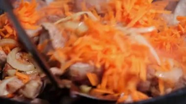 Tavada soğan ve havuçla güveç pişirmek. Ev yemeği..