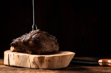 Ahşap tezgahta pişmiş bir parça et. Baharatlı fırında pişirilmiş domuz ya da sığır eti..