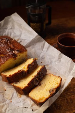Dilimlenmiş muzlu ekmek. Bitki çayıyla birlikte. Koyu tahta arkaplan.