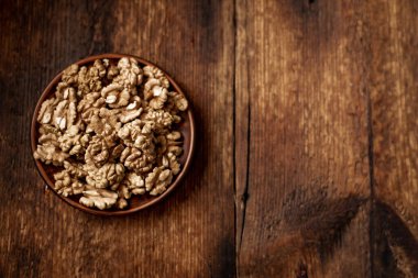 Tabakta soyulmuş ceviz. Koyu ahşap arka plan. Vejetaryen, sağlıklı yiyecekler. Yukarıdan bak. Metnin için yer.